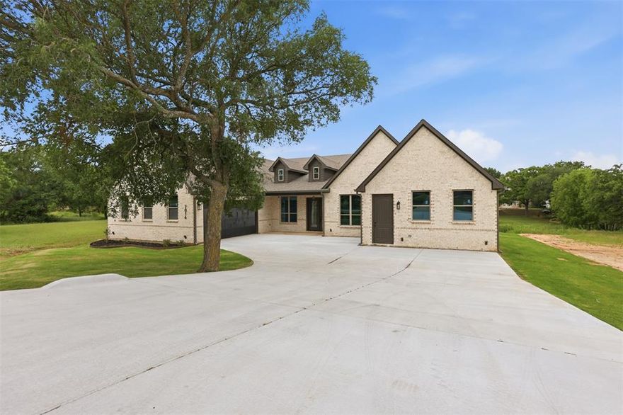 New construction in the sought-after Pecan Plantation, offering a thoughtfully designed layout with 4 bedrooms, 3 baths, a private office, and an oversized gameroom. From the extended front porch and double entry doors, you’re welcomed by soaring ceilings and rich wood flooring that set the tone for the entire home.

The open-concept floorplan is built for both everyday living and entertaining. The kitchen stands out with custom wood cabinetry, designer backsplash, a statement vent hood, and an oversized island with additional storage, all flowing seamlessly into the living room. A linear electric fireplace with a floor-to-ceiling accent wall creates a striking focal point, while the eat-in dining area overlooks the private backyard.

The owner’s suite is designed for comfort and style, featuring elevated ceilings, dual vanities, a large walk-in shower, freestanding soaking tub, and a spacious closet with custom built-ins and shelving.

The split-bedroom layout offers ideal privacy, with two secondary bedrooms sharing a hall bath, while a fourth bedroom is positioned separately with access to a full bath—perfect for guests or multi-generational living. An oversized gameroom adds flexible space for entertaining, media, or play.

Step outside through double sliding doors to a covered patio overlooking a fully fenced backyard with a retaining wall and peaceful nature views.

Additional highlights include foam insulation, quartz countertops, designer finishes, specialty lighting, and gutters.

Located in a gated, amenity-rich community with access to golf courses, pools, trails, and lake living—this home offers more than just a place to live, it delivers a lifestyle.