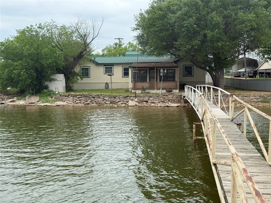 Here ya go folks. Nicely priced for your quick lake house. Five Bedrooms, Two and a half bathrooms. Nice size kitchen, big living room. Large master and master bathroom. Three Bedroom Double wide mobile home with two additional bedrooms added on. Lakeside covered porch with fantastic lake views. Large Detached Garage. Plenty of parking for all your lake toys. Upstairs floored area would make a great game room and or bunkroom. Gently sloping waterfront lot. Platform dock sitting in good water depth. Perfect set up for the elderly or the grandkids. Hard to find lake property in the price range. HURRY HURRY HURRY