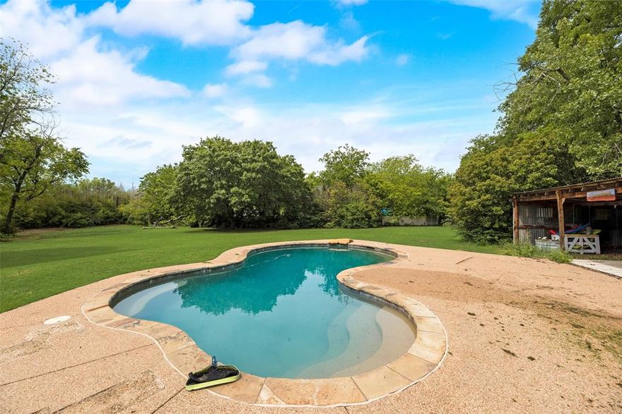 NO HOA. NO RESTRICTIONS. 1.672 ACRE PROPERTY. This versatile farmhouse offers space, privacy, and endless possibilities. The backyard is a private oasis featuring a pebble-finish pool, large deck, and metal party cabana, ideal for entertaining. Inside, the home features an open galley kitchen with new soft-close cabinets, granite countertops, and a 5-burner gas stove. A cozy breakfast room sits off the kitchen, with a formal dining room on the other side for easy flow. The spacious primary bedroom offers a sitting area and multiple closets. The living room showcases a classic wood-burning fireplace that efficiently heats the home. The expansive lot includes a 26x32 metal building on a slab and 14’ ceilings, perfect for storage, equipment, or a auto workshop. There is also an oversized garage connected to an 11x24 workshop or man cave. Plenty of room to park RVs, boats, or multiple vehicles for a business. Additional upgrades include a premium metal roof (insurance-friendly), new electric panel, large water storage tank, and freshly painted white exterior brick. A brand-new high-end solar system with a lithium battery and upgraded panel will keep your electric bills low. With no HOA, this property offers rare freedom to expand or build additional structures. Seller is open to selling home as a package deal with the income-producing lot that is one lot over form home. This lot comes with a private water well supplying 11 homes (MLS# 20969286, 4724 E University Dr., Denton) and is open to packaging both properties together. Multiple neighbors open to possible selling. Opportunity to buy just under 3.5 total acres with purchase of connecting 4 properties and own the entire corner. Acreage, privacy, and flexibility like this are nearly impossible to find at this price point. Come make this property your own.