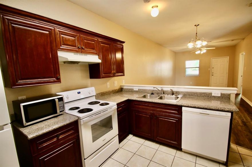 Free November rent with an 18 months lease. This spacious 3 bedroom, 2 bathroom duplex offers a comfortable and modern living experience. The home features beautiful tile and wood vinyl plank flooring, creating a cohesive and elegant look throughout. The open kitchen is a focal point, boasting dark wood cabinets and including kitchen appliances, perfect for preparing meals and entertaining. The master bedroom suite provides a private retreat. The wood-fenced backyard includes a covered patio that's an ideal space for outdoor relaxation. The attached garage provides convenient parking and additional storage space. Its prime location offers easy access to freeways and shopping centers, making daily commutes and errands a breeze