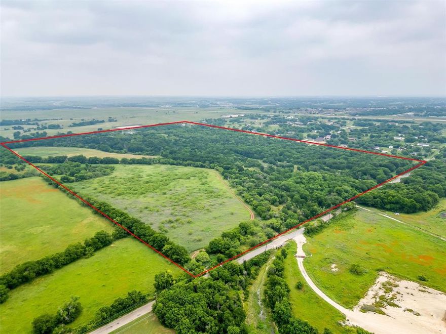This expansive 100.79 acre tract offers a rare combination of natural beauty, prime location, and unlimited potential. Located in the sought-after Joshua ISD and just outside city limits, the property is ideal for residential development, a private homestead, livestock, farming, or recreational use. Rock Creek winds through the center of the land, framed by mature trees that add character and privacy. Two stocked ponds offer peaceful views and great fishing. Water and electric are available, making future development or building that much easier. Less than half a mile from the Chisholm Trail Parkway, this property offers the perfect balance of quiet country living with quick access to Fort Worth for shopping, dining, and entertainment. Whether you’re looking to invest, build, or just spread out and enjoy wide-open space, this is a rare opportunity you won’t want to miss.