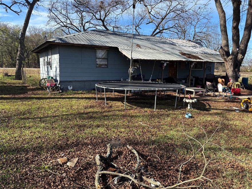 House with 5.6 acres at the corner of Hwy 11 and FM 1553.  Come take a look and then take advantage of this opportunity.  The property has many mature pecan trees and has a Burr Oak creek as it's North border.  There has a perimeter fence that will hold animals with minimal work. There is also a loafing shed to shelter any stock you may have. The home needs some TLC and updating but has good bones. No restrictions