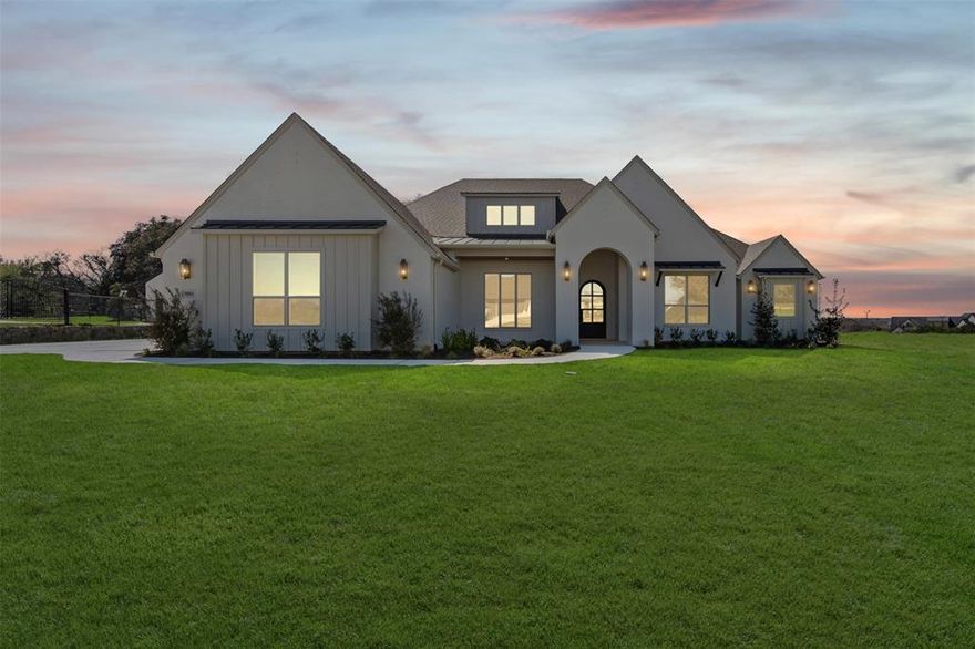 Built by award-winning Couto Homes, this Modified Catalina Signature Series residence is a striking showcase of refined design & thoughtful luxury in the gated SouthBend Estates community on Lake Granbury. Offering 3,431 square feet, this 4-bedroom, 3-bath home also features a private study, expansive game room, & a 3-car garage, all set on a generous 1+ acre lot with concrete streets & impeccable curb appeal highlighted a painted brick exterior featuring board & batten accents & distinctive metal awnings with a dramatic iron entry door. Inside, coffered ceilings crown the living room, anchored by a sleek cast-stone surround fireplace, creating a warm yet sophisticated focal point. The open-concept living, dining, and kitchen flow effortlessly, ideal for both intimate evenings & grand entertaining. The chef’s kitchen impresses with abundant storage, a blend of glass-front & solid Knotty Alder custom cabinetry, an oversized island with breakfast bar, gas cooktop, pull-out microwave, dishwasher, & a show-stopping walk-in pantry complete with appliance cabinet, open shelving, rollout drawers, & prep counter. The primary suite is a private retreat, boasting a spa-worthy ensuite with an elegant elliptical arch wet room featuring dual shower heads & a freestanding soaking tub for ultimate relaxation. Three additional bedrooms and two full baths provide comfort and privacy for family and guests alike. A spacious game room offers endless versatility, while the mudroom & well-appointed laundry add everyday convenience. Designer finishes & curated color schemes elevate every space. Open cell foam insulation with radiant barrier, 14 SEER HVAC system, stained tongue & groove porch ceilings, epoxy garage flooring, 10,000 SF pro landscaping, 492 SF of covered porches. Just minutes from Granbury & a short 30-minute drive to Fort Worth, this home delivers luxury living with effortless access to city conveniences, all within one of Lake Granbury’s most prestigious gated communities.