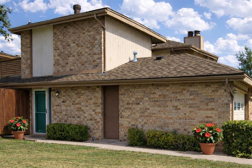 Spacious and well-maintained 2-bedroom, 2-bath home featuring a desirable split floor plan. The upstairs bedroom and bathroom offer added privacy and include access to a private balcony.

The home includes several attractive upgrades such as window and sliding-door shutters, stainless steel kitchen appliances, and light-colored luxury vinyl plank flooring throughout the main floor. The living room features a cozy wood-burning fireplace and opens to a private courtyard through sliding glass doors. The courtyard also connects directly to the primary bedroom, creating a relaxing outdoor retreat.

The downstairs bathroom includes a handicap-accessible walk-in bathtub. Carpeted stairs lead to the upstairs bedroom, which also features carpet flooring. The second bathroom includes a shower tub combination.

A large grassed area with a mature shade tree sits just outside the front door, providing a pleasant outdoor setting and additional open space to enjoy.

Additional features include a two-car garage and access to community amenities such as tennis courts, a swimming pool, and a clubhouse. The pet-friendly community adds to the appeal and provides a welcoming environment for animal lovers. Conveniently located near DFW Airport with easy access to the entire metroplex.
Home is currently owner occupied. Open to a quick close.