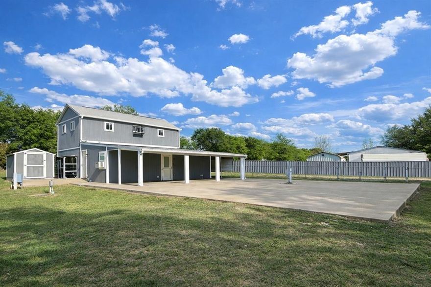 Whether you’re seeking a weekend getaway, full-time residence, or income-producing property, this home checks all the boxes.

The home features two separate living areas, creating the perfect setup for entertaining, or added privacy. One living space includes a washer, dryer, and utility sink, while the second living area is enhanced with decorative lighting for a warm, inviting feel. An eye-catching accent wall with refurbished wood continues through the living space and up the staircase, adding character and charm throughout. The oversized upstairs bedroom offers plenty of space, with the potential for a second bathroom upstairs.

The property includes a concrete pad, two RV hookups, an extra-long driveway, and a carport—ideal for guests, additional parking, or recreational use. A storage shed with electricity adds even more versatility.

The exterior is fully fenced with a combination of metal privacy fencing on each side and chain-link fencing around the front and back. There are multiple double gates for easy access. Two large oak trees provide shade in the front yard, while outdoor safety lighting and rain gutters with extensions add both convenience and peace of mind.

Residents of Holiday Villages of Fork enjoy access to a wide range of amenities, including fishing piers, boat ramps, a saltwater pool, clubhouse, playgrounds, picnic areas, and a full calendar of community events such as bingo, karaoke, potlucks, and painting classes. HOA dues are just $52 per month, with community well water filtration and sewer services available at $65 each per month plus usage.

Don’t miss your chance to own a feature-packed property in one of Lake Fork’s most sought-after gated communities—bring your golf cart, boat, RV, and your fishing pole!
