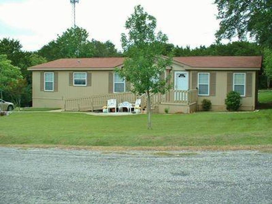 VERY WELL CARED FOR 2004, 3 BD 2 BA home with room for RV-Boat-Trailer parking! This is an Oak Creek MODULAR HOME (not mobile), and has a warranty deed with 3 lots that total approx .43 acres. Great open floor plan in excellent condition! Textured sheetrock throughout house with bull nose corners. Large living & dining rooms, large kitchen & breakfast area with lots of cabinets & nice pantry. Wood burning FP & vaulted ceilings. Large separate Master BD with spacious bath with garden tub & separate shower, large walk through closet, double sinks & linen cabinet! Big utility room with full sized W-D area with clothes racks, extra room for freezer, ironing board, or drip dry area for clothes. Landscaping with sprinkler system, large fenced private back yard with storage building, easy access ramp to front door, cement walkway & drive with lots of parking. Great location on the FW side of town. Property extends well beyond the fence. Community pool, boat ramp and fishing dock!