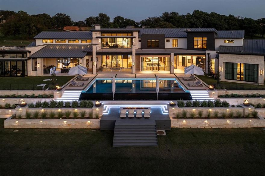 Welcome to a one-of-a-kind modern transitional estate built by Cary Hy nestled within the prestigious, gated community of Quail Hollow in Westlake. Completed in 2024, this magnificent lakefront residence combines cutting-edge luxury with serene natural beauty. With over 15,000 square feet of exquisitely designed interior space, the property offers a wealth of amenities and extraordinary upgrades. The residence features an infinity-edge pool with captivating fire features, seamlessly blending into the lake views. An expansive six-car garage also provides space for boat storage. The main level boasts a grand master suite also complete with sweeping lake views, his-and-hers closets, and discreet access to a secure safe room. Entertainment and recreation are paramount, with a private pickleball court, full bar, oversized theater, sporting simulation center, fully-equipped gym, podcast studio, kids’ gaming and homework lounge, and even a gift-wrapping room. A stylish bunk room adds charm, while the extensive outdoor living area offers a covered entertainment space, complete outdoor kitchen, and integrated media, creating the ultimate experience for lakeside living. This estate represents an unparalleled lifestyle in Westlake’s most exclusive community.  Walk Through video and additional photos available to qualified buyers.