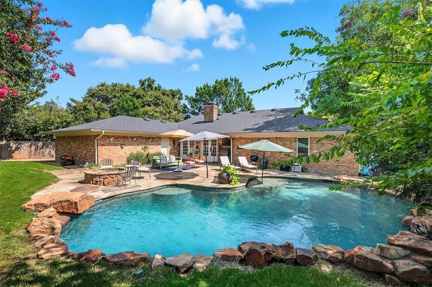 This traditional one-story home offers timeless curb appeal in the heart of Fort Worth and is zoned to coveted Overton Park Elementary. Situated on a beautiful street and perfectly located near central shops, grocery stores, restaurants and major highways, it places you at the hub of the city. Wide-plank wood floors flow through the main living areas, leading to a remodeled kitchen with stainless steel appliances, granite countertops, a breakfast bar and glass-front cabinetry, perfect for displaying favorite pieces. The kitchen opens seamlessly to the family room and sunroom, creating an versatile and inviting layout. The gracious family room has vaulted ceilings and is grounded by a brick wood-burning fireplace, adding warmth and character. The home offers four bedrooms and two and a half baths, including a primary suite with dual vanities, a remodeled shower with a seamless glass surround and two walk-in closets. The secondary bedrooms are nice sized and share a Hollywood bathroom. The backyard is a true Texas retreat, featuring a sparkling pool with a waterfall, natural rock accents and sunning platform. The backyard also features a flagstone patio for gathering, stone firepit and plenty of grassy area for play. A gated drive and two-car garage complete the package. Come experience this Overton West treasure and make it your own!