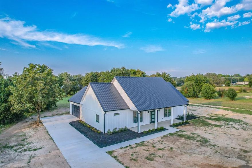 Completed in September 2025, this brand-new custom home showcases exceptional craftsmanship, modern efficiency, and timeless comfort. Set on 2 serene acres with approximately 190 feet of frontage along quiet Country Lane, the property offers a peaceful country setting just minutes from schools, shopping, and the recreational beauty of Cedar Creek Lake. The 1,924 sq. ft. interior is thoughtfully designed for everyday living and entertaining, complemented by expansive outdoor spaces—a 271 sq. ft. front porch, a 410 sq. ft. back porch, and a 574 sq. ft. garage that is fully insulated, heated, and cooled. Built with durability in mind, the home features board-and-batten smart siding with zip-board sheathing, a commercial-grade 26-gauge R-panel metal roof, and seamless gutters for long-lasting performance. Energy efficiency is at the forefront with open-cell spray foam insulation (4” in walls, 6” in ceilings), insulated garage door, and energy-efficient double-hung windows. The foundation boasts 18-inch beams with a 4-inch slab for superior strength. Inside, high-end finishes include custom cultured marble in the bathrooms, marble countertops in the kitchen, laundry, and outdoor kitchen, plus a full suite of GE stainless steel appliances. For modern convenience, the home is pre-wired for security cameras, internet, and a whole-home stereo system. Additional upgrades include a brand-new aerobic septic system installed by Weaver Excavating, along with City of Malakoff water and trash service. For those needing more space, an additional 2 acres are available, featuring a versatile metal shop complete with its own septic system, bathroom, and climate control—perfect for a workshop, business, or guest accommodations. Every detail of this property reflects quality, comfort, and thoughtful design, making it a rare turnkey opportunity in Malakoff ISD.