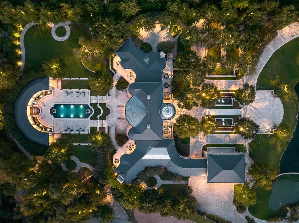 Surrounded by meticulously landscaped gardens and scenic walking trails, The Forty seamlessly merges natural beauty with modern luxury, creating an idyllic sanctuary in the heart of DFW. Its serene seclusion is perfectly balanced with easy access to the vibrant communities of Highland Park, Preston Hollow, Plano, and Frisco, offering the best of both North and South. The main residence is an architectural masterpiece, designed to blend timeless materials with modern functionality. Expansive indoor-outdoor living spaces invite effortless flow throughout the home. A grand reception hall leads to the owner’s private wing, which includes a luxurious office, an exercise room, and a grand master bath with spa-like amenities. The west wing is dedicated to entertainment, featuring a stylish bar lounge, a state-of-the-art chef’s kitchen. In addition, upstairs there is a library, home theater, bar, and a beautiful living area. The ground level reveals a stunning cabana-game room, a wine cellar, and a dedicated massage room with a large steam shower, all opening to outdoor spaces. The northern grounds of the estate boast a resort-style pool and an elegant garden pavilion, a setting perfect for hosting exclusive events with capacity for up to 600 seated guests. The Forty is set on 6.38 acres of private, landscaped grounds, this property offers over 20,000 SF of living and entertaining space, including a guest house, and staff quarters in the main house. The estate's amenities include a private freshwater pond, a tennis court with adjacent party powder rooms, a putting green, and a multi-purpose pavilion that can serve as an entertainment venue, sports court, or a garage accommodating up to 26 cars with lifts. Two gated entrances ensure both privacy and ease of access. This estate is more than just a home—it’s a lifestyle. A place to create memories, to entertain in unparalleled style, and to experience the pinnacle of elegance and comfort.