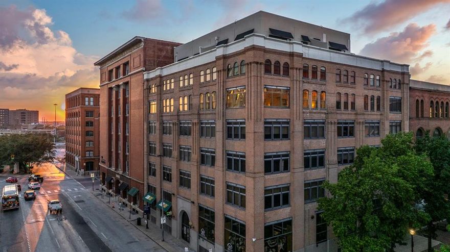 Sleek Designer Loft – Rare Corner Residence in Downtown Dallas. Discover one of downtown Dallas’s most striking lofts—a coveted 5th-floor corner unit set within a beautifully preserved historic building. Thoughtfully reimagined as a designer’s personal residence, every detail has been carefully curated for both style and comfort. Walls of windows flood the space with natural light, highlighting warm white oak hardwood floors with full soundproofing and soaring ceilings that create a sense of calm and privacy. The kitchen impresses with custom cabinetry, exotic quartzite countertops and backsplash, and statement lighting that elevates the entire space. Both bathrooms have been fully transformed with clean, modern finishes, illuminated mirrors, and a spa-inspired soaking tub, while Hunter Douglas window treatments and a custom closet system add refined, upscale touches—making this a rare turnkey opportunity to experience elevated downtown living.