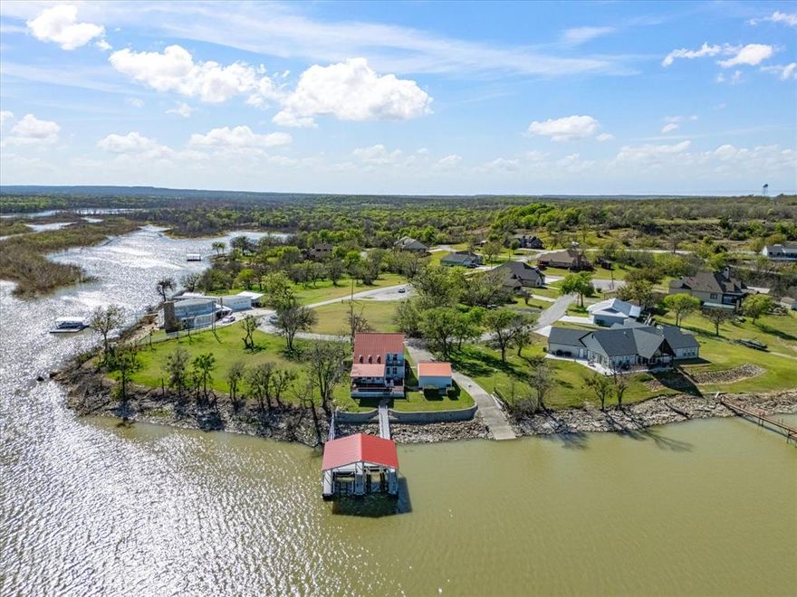 Welcome to 707 Marco in beautiful Lake Bridgeport! As you drive across the bridge to Runaway Bay you will see this red roof resting peacefully on the outermost point of the land in a prime spot that commands incredible panoramic, open water views! This well-maintained home is spacious with 3 BR & 3 full baths. The main living room has gorgeous lake views, vaulted ceiling & skylights that bathe the home in natural light & brings the outdoors inside!  The enormous recreation room is perfect for leisurely afternoons reading on a day bed, large enough for a pool table & ping pong table, and well-suited for weekend guests & large family gatherings! The kitchen & dining room are generous in size with tons of cabinet space! Outside you can enjoy the peaceful surroundings on the covered deck, open deck, upstairs balcony, or grassy lawn! This property includes a top-of-the-line Wahoo covered floating double boat dock with power lift & lighting, its own private boat ramp and detached garage! There are 3 bedrooms, 1 on the lower level & 2 upstairs, both with en-suite full baths & both with breathtaking lake views to greet you every morning! LakeLife is the best life! This community has NO HOA but offers many community features such as golfing, fishing, boating & lake activities, RV parking, restaurants, a marina & more! Located in city limits of RB so it features city water & city sewer.   Seller also owns the 2 empty waterfront lots next to this one & the 2 lots across the street, & is open to give first rights to purchase those to the buyer of this home! This wonderful property has been well-loved & well-maintained, & now it is ready for its next chapter! This is an amazing opportunity to own the lakehouse you've been dreaming of where you can enjoy all the extras that come with living at the lake with the views, the beauty of nature, the relaxation & the abundantly enriched lifestyle of lakelife year-round!   Tours begin Sat. March 28th & Open House 2-3 pm Sun. March 29th