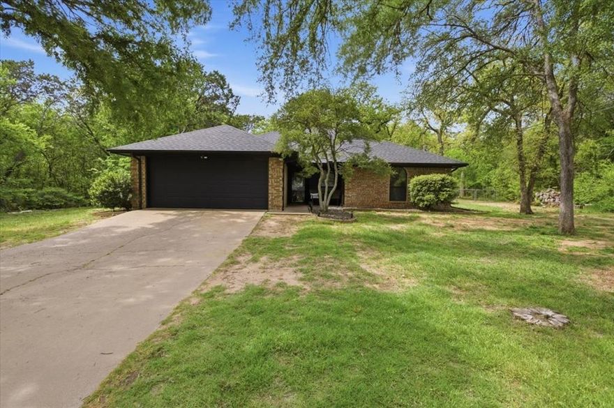 Welcome home to your own little paradise in the heart of Granbury.  Nestled in the back of the highly sought-after Spanish Trail neighborhood, this hidden gem offers the perfect blend of privacy, comfort, and small-town charm. With very little traffic in this quiet section of the community and heavily wooded lots on both sides, you’ll enjoy a peaceful, secluded setting that truly feels like a retreat.  This inviting 3-bedroom, 2-bath home features a flexible bonus room thoughtfully built out in the garage — ideal for a second living area, kids’ game room, home office, or media space. Whether you're hosting family movie nights or giving the kids their own hangout spot, this extra space adds versatility to fit your lifestyle.  Living in Granbury means embracing a high quality of life with the warmth of a close-knit community. Known for its small-town charm and the beauty of Lake Granbury, the area offers outdoor recreation, historic downtown shopping, and year-round events — all while enjoying more affordable living and lower property taxes than many surrounding areas. And when you’re ready for big-city amenities, Fort Worth is just a convenient drive away.  If you’ve been looking for privacy, community, and comfort all in one place, this Spanish Trail treasure is ready to welcome you home.