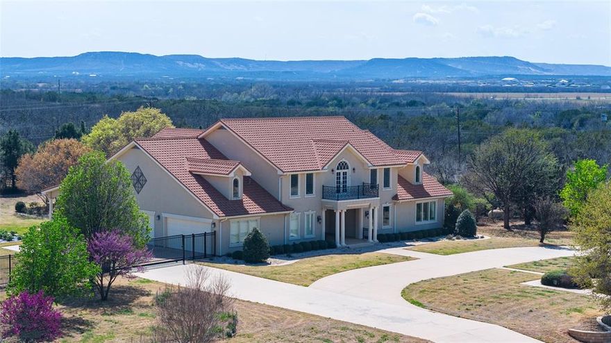 Over 2 acres of prime Southwest Abilene with views, privacy, luxury and ability to use this stunning property in many ways since it is not part of an HOA. This unique one owner home was custom built with living well in mind - each bedroom (2 primary downstairs and 3 upstairs) has an ensuite bath and large walk in closet.  Several rooms could also be bedrooms since they have closets, and have served as workout, media, meditation and office space.  All 5 bedrooms have no common walls, so occupants are assured of privacy, and can then enter the large common areas where soaring ceilings, marble floors, and decorative light fixtures set the stage for entertaining, events, or simply shared time.  The beautiful kitchen has incredible views and all top end appliances including warming drawer, double dishwasher and SubZero fridge freezer. There is an extra refrigerator and freezer in the large laundry room with a nearby laundry chute from upstairs. The yard is fully landscaped with roses, fruit trees and aromatic shrubs.  A  lighted sport court is currently set for basketball and easily converts to your favorite raquet sports like pickleball.  New hot water heaters, new carpet downstairs and fresh paint throughout the home so that it is move in ready for you.  So lightly lived in by previous owner that it truly feels like a new home - with quality materials not seen in most current new construction such as solid wood custom cabinets and trim throughout the home. The property has an iron fence perimeter with a security gate and security lighting and system to add an extra layer of confidence that there is no place like this home - see and make it yours.