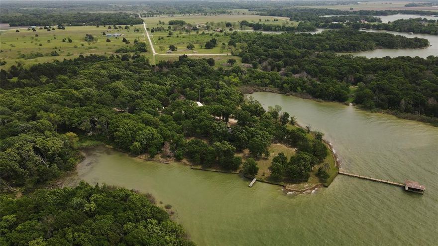 A secluded, waterfront estate with a unique combination of 2000 ft of shoreline and 26 wooded acres on highly desirable Richland Chambers Lake. Relaxation starts as you drive down the long, tree lined driveway to a private, waterfront getaway that includes a home with guest qtrs., 30x40ft workshop, and boathouse. Experience the ultimate lifestyle with privacy and southern breezes. You are surrounded by abundant wildlife in a food forest with a fruit orchard, blueberries, and blackberries. Large chicken house in place for fresh eggs. Separate, climate controlled, 1394 sq.ft. animal building used as a kennel with many possibilities. 
The home is recently updated and expanded to include a large owner's suite with vaulted ceilings, ensuite bath , dressing area with closets, and an exercise or office area. You will enjoy lots of windows with Lake views and a patio for your morning coffee or spa time. Plenty of space for cooking and gathering in the fully remodeled kitchen with breakfast area.  Enjoy the extensive wild bird activity with ducks, herons, ospreys, and more from the adjoining dining room and cozy seating area with a large wood burning fireplace. A perfect place for wintertime gatherings and smores. Large, windowed family room with a covered walkway to 960 ft. open living space, with kitchenette and bath. So many possibilities, guest suite, entertainment room, or additional family space all with water views. Covered porch facing the Lake and side patios for outdoor enjoyment. 
Ready for all the fun of fishing, boating, water sports, and swimming with the protection of a deep water, wide cove with open water view. A dream come true for your family for years to come. 
 Minimal deed restrictions and no HOA for many possibilities for getaway or investment! Must see to appreciate all this property has to offer. Conveniently located just off U.S. HW 287 with easy access to DFW.  Property has an additional, non-taxed TWRD easement of appx. 7 ac.