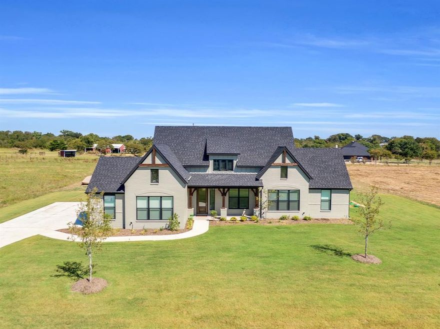 APPRAISED WELL OVER ASKING PRICE! Gorgeous ALMOST NEW Modern Farmhouse built by Elmwood Homes on just over an acre! The home is located in the beautiful new subdivision of Waterfall Ranch just outside Waxahachie city limits! A gorgeous custom door designed with waterfall glass panes greet you at the entry of this home. Upon entering the home, warm natural light invites you into the open layout with vaulted ceilings, custom wood beams, and gorgeous quartz countertops throughout. The high end finishes and flawless lighting create the perfect balance of peace and tranquiltiy throughout the home. The kitchen offers a spacious walk in pantry and ample counterspace surrounded by a beautiful mosaic backsplash, custom wood cabinetry and floating shelves. The grand size island offers a farm sink, quartz countertops, and room for several barstools. The gorgeous brushed gold finishes continue upward into the beautiful light fixtures in the kitchen and dining areas. The primary suite is the perfect retreat that includes an en suite that feels as if you've entered your own personal spa. This retreat offers a stand alone bathtub and spacious his and her walk in closets. This home includes a total of four bedrooms, two baths, an office, and a media room. The laundry room has a mud bench with custom cabinetry for all of your storage needs. In the three car garage there is also a storage closet and epoxy flooring. The entire home has encapsulated foam insulation to help keep your home cost effiecient during the most extreme weather conditions year round. There is an electric car charging outlet in the garage. This home is located about one mile from Intrestate Highway 35 and is within minutes of shopping, entertainment, and schools. Enjoy the benefits of country living just minutes away from all that the city of Waxahachie has to offer! Home is priced under recent appraisal value!