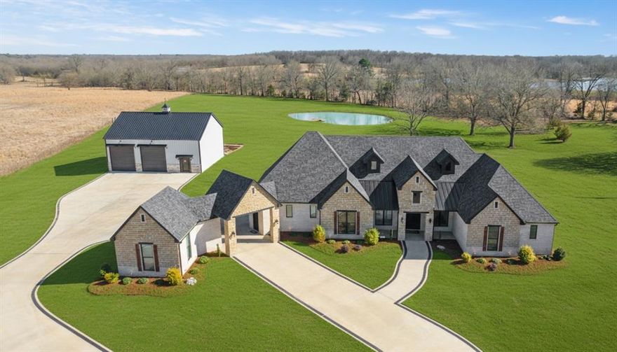 Just northeast of Paris, this exceptional custom built estate sits on approximately six acres, offering the perfect blend of refined luxury and peaceful country living. Designed with both comfort and entertaining in mind, this 3-bedroom, 2.5-bath residence has an expansive open floorplan featuring a gas fireplace and stunning multi-panel sliding glass doors that flood the living space with natural light and open seamlessly to a fenced in back yard.

You can truly say this is a chef’s kitchen, showcasing custom cabinetry, premium countertops, a hidden walk-in pantry, and commercial-grade appliances including a Wolf range and commercial refrigerator — a dream setup for serious cooking and hosting. The private primary suite is its own retreat, complete with a cozy gas fireplace, an oversized walk-in closet with a built-in safe room, and a spa-inspired bath highlighted by a walk-around tile shower. The secondary bedrooms are thoughtfully connected by a Jack-and-Jill bathroom, offering both privacy and convenience.

Outdoors, the property continues to impress with a 40x45 insulated shop featuring two roll-up doors, ideal for projects or storage. A picturesque pond with dock provides a scenic backdrop and space to unwind. Additional features include a two-car attached garage, a porte-cochère attached to a separate one-car garage and a back up generator system.

With upscale finishes, intentional design, and room to breathe, this one-of-a-kind acreage property delivers elevated country living just minutes from town.