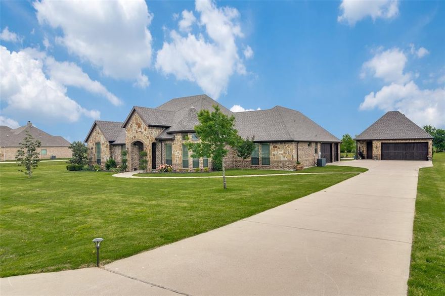 Beautiful custom-built home, set on 1.7 acres within a small, quiet gated community, is a must see for discerning buyers. As you enter, you are greeted by an upscale interior adorned with rich hardwood flooring, beautiful lighting and a stunning beamed ceiling in the family room. The chef's kitchen, a true centerpiece, features an oversized island, granite countertops, custom cabinetry, a pot filler, and premium stainless-steel appliances, perfect for culinary enthusiasts. The home offers spacious living areas, and a sophisticated office that includes a walk-in closet so it can transform to a 4th bedroom. The oversized primary suite provides sequestered privacy with beautiful details and large windows looking over the large backyard. There is another extra large bedroom that provides privacy that could be perfect for an in-law or guest suite. The oversized utility room has cabinets galore and more. The beautifully covered patio, with a cathedral ceiling, provides a tranquil retreat with gas installed on the patio for an outdoor cooking area if desired. The property boasts an attached three car garages. A detached 780 sf workshop with garage spaces has electricity, water and roughed-in plumbing to easily add a bathroom.  Additionally it has ATT fiber and NO MUD tax or PID. Bring your offers. This is luxury living at its most attainable.