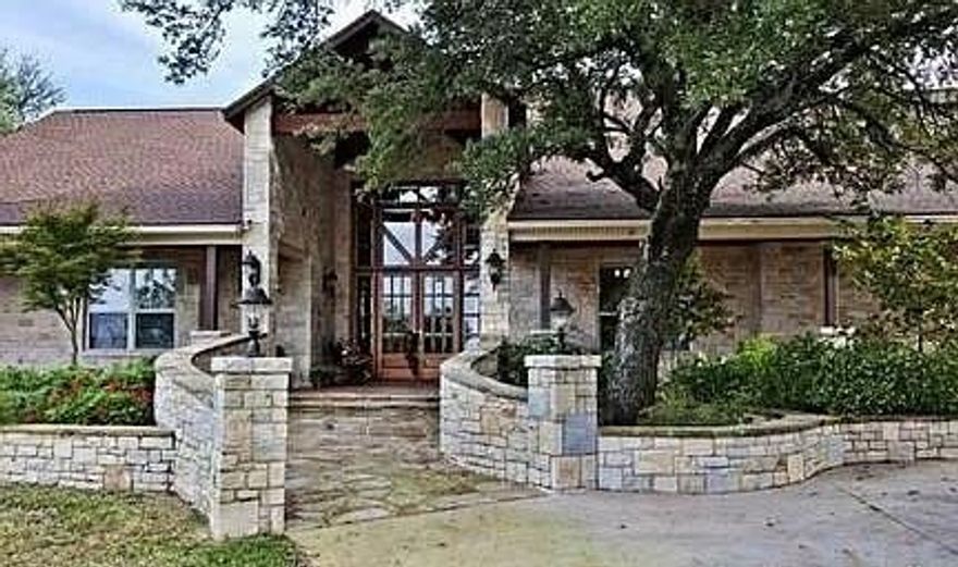 This spectacular 1.27-acre property in Palo Pinto County offers panoramic, unobstructed views and a serene, park-like setting that must be seen. Overlooking the scenic Brazos River, the home welcomes you with beautiful rockwork and an impressive eight-foot stone cross at the entry. The magnificent family home features large covered porches across the front, perfect for relaxing, and a spacious south-facing back patio that captures the sweeping beauty of the Brazos River valley.  

Inside, you’ll find an open floor plan with ten-foot-plus ceilings and a striking rock fireplace. Handcrafted walnut cabinetry and built-ins are featured throughout, while the chef’s kitchen is fully equipped with commercial-grade appliances for both casual and gourmet cooking. The split-bedroom layout includes three bedrooms, with a master suite offering a spacious walk-in closet, granite countertops, an oversized tub, separate walk-in shower, and a private sauna. A bonus exercise room can easily serve as a fourth bedroom, and one guest room includes a Murphy bed—ideal for a home office or multipurpose space.  

Additional highlights include a game room with a rustic antique bar. Home has plantation shutters and solar shades, and a separate mud and utility room. The property also includes a rear entry two-and-a-half-car garage with an attached RV building or workshop. Whether you’re enjoying the peaceful scenery, listening to the sounds of wildlife, or relaxing on the porch, this home truly shines like a diamond with its breathtaking views and timeless beauty.