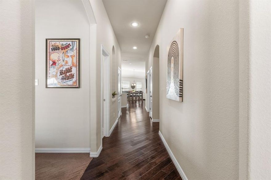 **2-HOUSES (ACROSS THE STREET FROM EACH OTHER) OPEN HOUSE - SATURDAY, APR 4th, 12-2pm!**  Exquisite single-story, energy-efficient home in the master-planned community of Trinity Falls in North McKinney. Lush trees and manicured landscaping frame the striking brick and stone façade, highlighted by a distinctive herringbone detail and elegant copper window awning, while an arched entry leads to the inviting brick front porch complete with a Ring doorbell and keyless entry. Inside, a dramatic circular foyer with tray ceiling sets the tone. Engineered wood floors flow throughout the main living areas. A versatile front bonus room—ideal as a home office, media, or game room—is wired with a Denon smart-home sound system for listening to music or watching the big game with surround sound. The private primary suite, accessed through French doors, features vaulted ceilings, four sunlit windows, custom built-in shelving, a sitting area, and two generous walk-in closets. End a long day in the spa-inspired bathroom, which offers dual sinks with granite countertops, a soaking tub beneath a large window, a walk-in tile shower with body spray, and a private water closet. Enjoy cooking and baking in the eat-in kitchen that boasts white cabinetry with deep drawers for pots and pans, granite countertops, tile backsplash, walk-in pantry, and an island with undermount dual sink and upgraded pull-down faucet. Host dinner parties or family meals in the light and bright dining area and gather your loved ones in the cozy living room, anchored by a gas fireplace and vaulted ceilings, with patio access for seamless indoor-outdoor living. The covered patio is an entertainer’s dream, showcasing a vaulted pine ceiling with fan, in-ceiling speakers, and gas stub in place for outdoor grilling. A spacious backyard with grassy play area completes the setting. Community amenities include pools, ponds, dog park, pickleball, playgrounds, Frazier Elementary, and easy access to Hwy 75.