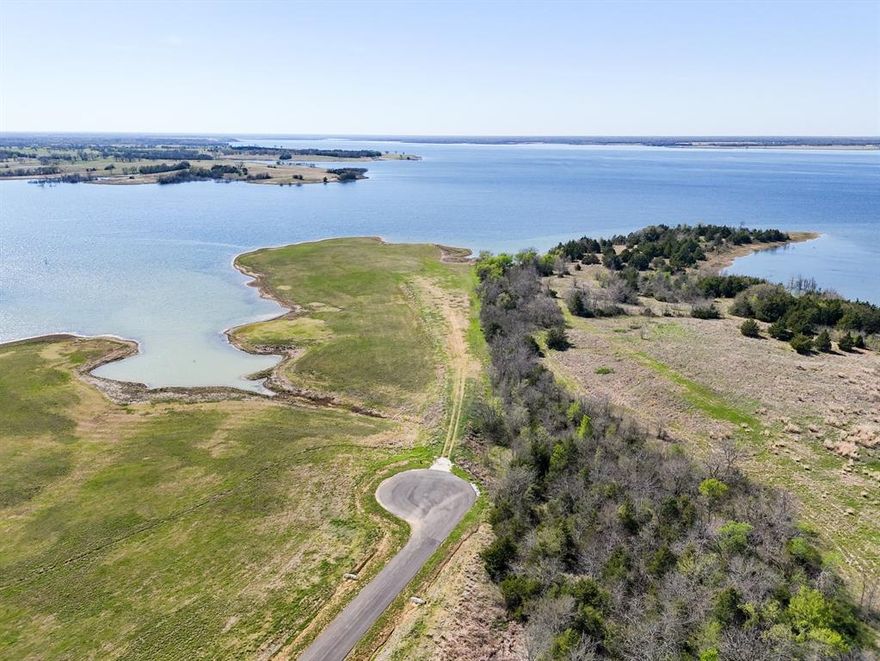 Introducing what may be the most coveted, deep water lakefront estate in all of Texas. The scale, setting, and extraordinary views of this one-of-a-kind property place it in a class of its own. Welcome to the northern point of Lakeshore Terrace in The Five Points subdivision—a premier estate lot privately positioned at the end of a quiet cul-de-sac. Encompassing more than five acres, this remarkable parcel offers sweeping, unobstructed lake views and is uniquely large enough to accommodate two homes—an extremely rare opportunity unmatched anywhere else on Bois d’Arc Lake. This multiple dock-capable estate delivers dramatic 300-degree panoramas across the water, offering unforgettable sunsets night after night. Design and build your custom lakefront retreat with room for an infinity pool, guest home, and private boat dock. Enjoy peace, privacy, and postcard-worthy vistas, all just moments from shopping and dining in nearby Bonham. Paved roads provide easy access to US Highway 75 and the Sam Rayburn Tollway for a smooth commute to the northern DFW corridor. Residents of this upscale community enjoy first-class amenities, including a multi-million-dollar clubhouse, putt-putt golf, and a resort-style infinity pool. Investors will appreciate that short-term rentals are permitted with light restrictions. Come experience Bois d’Arc Lake for yourself and see why so many are choosing to make this exceptional lakeside community their home. BUYER AND BUYER'S AGENT TO VERIFY ALL INFORMATION CONTAINED IN THIS LISTING UP TO AND INCLUDING ALL NTMWD REQUIREMENTS FOR A PRIVATE BOAT DOCK.
