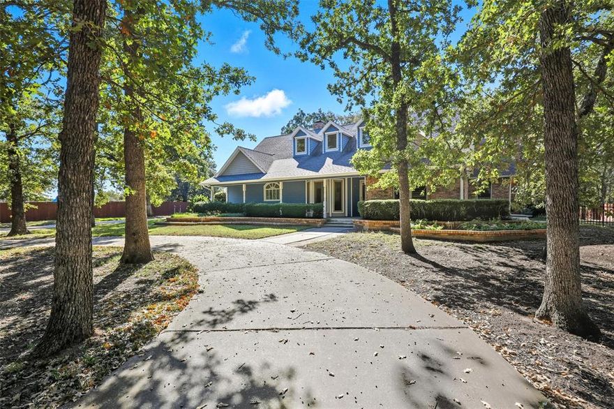 Welcome to your dream home, nestled on 2.62 beautiful acres in an incredibly convenient location! You'll love being close to schools, shopping, and the metroplex. This adorable house greets you with a charming gated circle drive and a cozy front porch, perfect for relaxing after a long day. Triple pane windows throughout make energy efficiency amazing! Inside, the inviting living area features warm wood floors and a wood-burning fireplace, making it the ideal spot for cozy winter nights. The bright kitchen is a true delight, boasting an island, stainless steel appliances, and plenty of cabinets and counter space for all your culinary adventures! You'll adore the spacious primary suite, complete with its own fireplace and an ensuite bath that has a jetted tub, separate shower, dual sinks, and a skylight to brighten your day! There's also an additional bedroom downstairs for convenience, while upstairs you'll find two more comfy bedrooms that share a cute bathroom. The huge great room is a versatile space that can become your media haven, craft room, or game room—whatever fits your lifestyle! Step outside to the peaceful back patio, where you can sip your morning coffee and enjoy the sounds of nature among the trees. Plus, there's a separate workshop with electricity, along with extra storage for your lawn equipment. Nine station sprinkler system perfect for keeping your landscaping blooming beautifully! This charming home truly has it all and is ready for you to create wonderful memories! Don't miss the chance to make it yours!