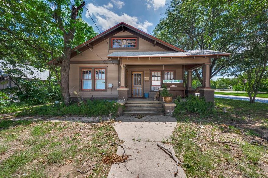 Full of charm and curb appeal, this classic bungalow style home sits on a large lot with beautiful mature trees. A welcoming covered front porch invites you to sit and enjoy the neighborhood. The location is fantastic, within walking distance to UNT and vibrant downtown Denton. Inside, you will find lots of windows and natural light, luxury vinyl plank floors downstairs, and an updated bathroom with a large walk in shower. The flexible floor plan offers two bedrooms downstairs plus an upstairs bedroom and living area. A convenient laundry closet, detached two car garage, and a back entry with a handicap ramp add to the appeal. The home is equipped with space heaters and window units. Some updates are needed, providing a great opportunity for the next owners to make it their own. The sellers are in the process of moving out.