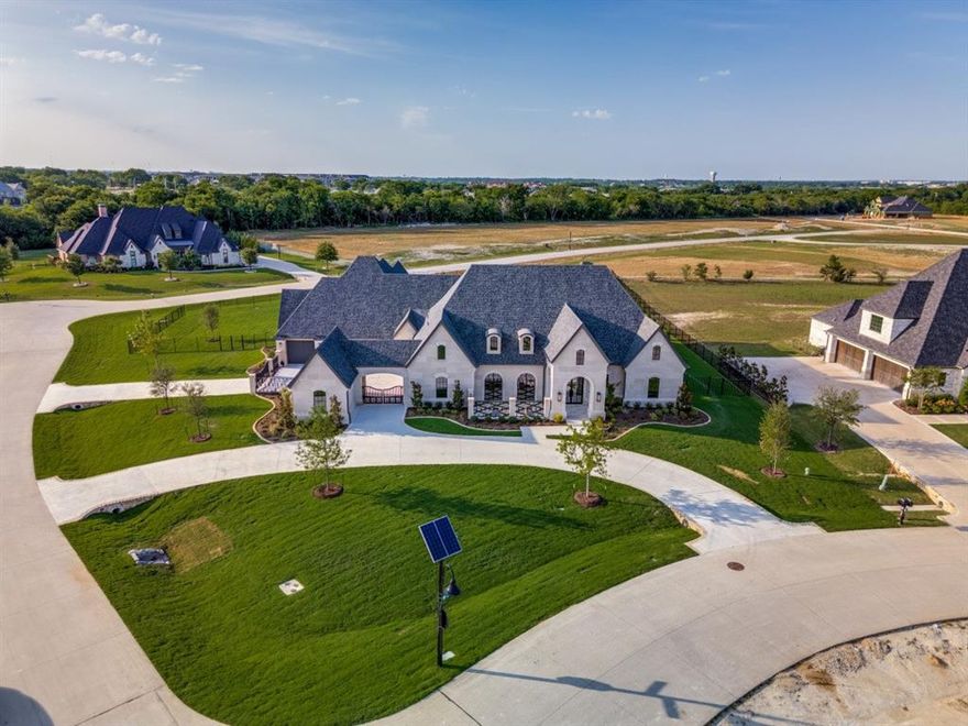 Stunning new custom home by one of DFW’s premier luxury builders, where no detail has been overlooked. This smart home is equipped with Lutron automation, pre-wired for electric shades, in-ceiling speakers, fully wired media room for projector, screen, ready for equipment of your choice. The striking buff Lueders stone exterior—a $400K upgrade, compared to the average standard stone, adds timeless beauty and unmatched durability.

Enjoy resort-style living with a large pool, hot tub, water features, upgraded in-ground cleaning system, artificial turf, and a private courtyard. Two separate entrances to the gated driveway, circular drive with full landscaping. The upscale chef’s kitchen features a massive island with Cristallo Quartzite waterfall edge, a 48” Wolf gas cooktop with griddle, double Wolf ovens, drawer microwave, built-in 36 in. refrigerator and freezer columns with custom cabinetry, built-in coffee maker, full-size wine fridge, butler’s pantry, and an oversized custom walk-in pantry.There is even a set of double fridge drawers under the coffee maker, for added convenience. Outdoor kitchen on the large covered patio has a masonry fireplace, built in gas grill with commercial vent, refrigerator, and a custom drop space for a smoker of your choice.

Thoughtful extras include a dog wash in the laundry room, epoxy coated garage floors, enclosed garage storage with shelving. The home offers five spacious bedrooms, each with ensuite baths and walk-in closets. The primary suite includes dual closets, one with a secondary laundry, and a smart toilet washlet. Additional highlights: a dedicated exercise room with access to the primary suite and a hidden safe room concealed behind a bookshelf in the office.
