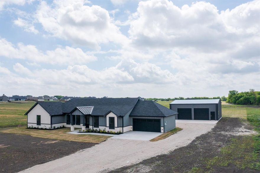 Set on a 1.465-acre tract, this newly constructed modern farmhouse offers country living with convenient access to the city. The property provides open views and a rural setting while being located just minutes from shopping, dining, and schools in Waxahachie.

The home features an open-concept layout connecting the living, dining, and kitchen areas. Multiple well-placed windows bring in natural light and provide views of the surrounding land. The kitchen includes quartz countertops and functional workspace for everyday use.

The property also includes a 1,600-square-foot shop, suitable for a variety of uses such as storage, equipment, vehicles, or workspace. The shop is equipped with a private half bathroom for added convenience.

Approximate access to major routes includes 10–15 minutes to Interstate 35E and 15–20 minutes to U.S. Highway 287, providing connections to Waxahachie and the greater Dallas-Fort Worth area.