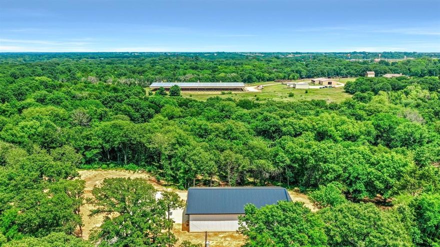 Hard to find heavily wooded acreage close to town and major highways. 50x75 metal shop on 7.912 acres with water and electrical available. Metal shop has 16 foot eave height & 2 foot eave overhang, black Pella windows, two 12 foot tall electric roll up bay doors, sliding doors, and covered porch. The metal shop is designed for a full living quarters (See plans) so you could finish it out and live here while your house is being built.
Home pad site is complete and is ready to build your dream home. This property comes with a full set of custom house plans, which includes 3,089 square feet, 3 bedrooms, 3 bathrooms, upstairs bonus room, and a full set of black Pella windows.
Do not miss this hard to find opportunity where the hard work is already done and you can get your house the way you want it.