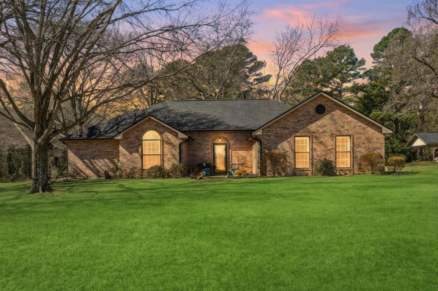 Situated on 5.26 acres along a quiet country road, this custom-built home offers peaceful rural living with convenient access to Interstate 20 and downtown Lindale. According to a recent sketch, the home provides approximately 2,087 square feet of living space, featuring three bedrooms and two and a half bathrooms in a functional, well-balanced layout.

The interior includes a spacious living area anchored by a wood-burning fireplace, creating a warm and inviting central gathering space. The open kitchen offers ample room for cooking and entertaining, with an efficient flow into the dining and living areas. A large walk-in laundry room is conveniently located off the attached two-car garage, supporting practical day-to-day living.

Outdoor improvements add significant versatility to the property. A covered RV parking area features a concrete slab measuring approximately 31 feet by 18 feet with 12 feet of clearance, complete with a 30-amp electrical hookup. A detached shop provides additional space suitable for storage, hobbies, equipment, or workspace needs. Multiple covered and open outdoor areas further enhance the usability of the acreage.

Mature trees, established landscaping, and open space contribute to a private setting with room to enjoy the outdoors or accommodate future improvements. This property offers a thoughtful combination of usable land, functional improvements, and comfortable living space in a desirable Lindale location.