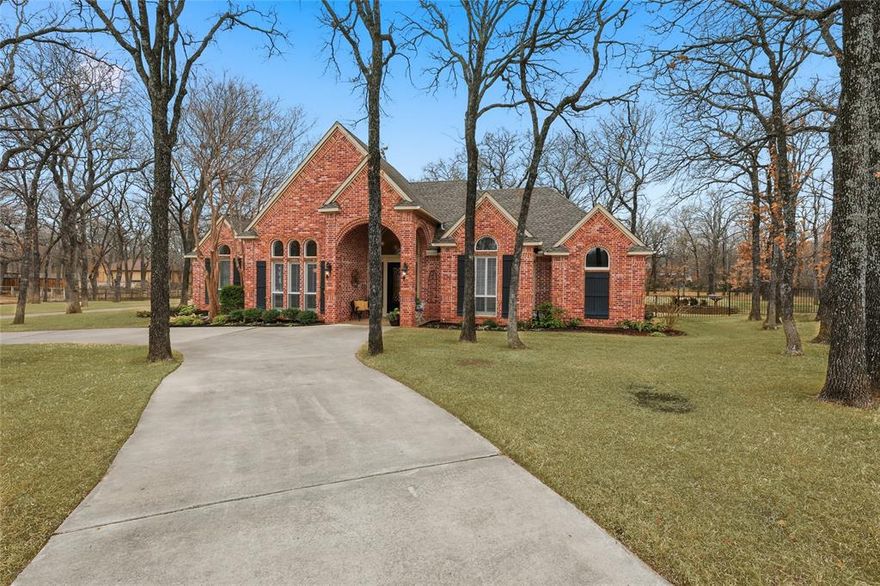 Situated on 1.5+ wooded acres in the prestigious Shadow Wood Estates community, this exceptional country luxury estate offers resort-style living in the heart of highly acclaimed Argyle ISD. Ideally positioned between Liberty Christian School and Hilltop Elementary, this property combines prime location with private, tree-lined tranquility.

Spanning 3,925 square feet, this 4-bedroom, 3-bath custom home is designed for elevated living and entertaining. The grand living room features soaring 12-foot ceilings and a dramatic wall of windows overlooking the manicured backyard oasis. Tray ceilings in both the formal dining room and primary suite add architectural distinction, while plantation shutters provide timeless refinement throughout.

The chef’s kitchen is thoughtfully updated with new soft-close cabinetry, double ovens, and a five-burner gas cooktop—perfectly suited for both everyday living and hosting on a grand scale.

The expansive primary retreat includes a private attached flex space ideal for a home office, executive library, nursery, or fitness studio. The spa-inspired bath offers dual vanities and a walk-in shower, creating a peaceful sanctuary within the home. Upstairs, two secondary bedrooms share a Jack-and-Jill bath and connect to an impressive 21x32 game room designed for entertainment and gatherings.

Step outside to your private backyard resort featuring a heated pool and spa with waterfall, covered patio, raised garden beds, mature oak trees, and professional landscaping. Wrought iron fencing encloses the grounds and pool area for both elegance and security.

For car collectors, entrepreneurs, or hobbyists, the property delivers unmatched functionality with a 3-car attached garage plus a 667 sq ft climate-controlled workshop complete with mini-split HVAC, epoxy floors, two additional garage bays, side carport, and abundant parking via the circular driveway. Voluntary HOA. Pool table and exterior cameras will convey with property.