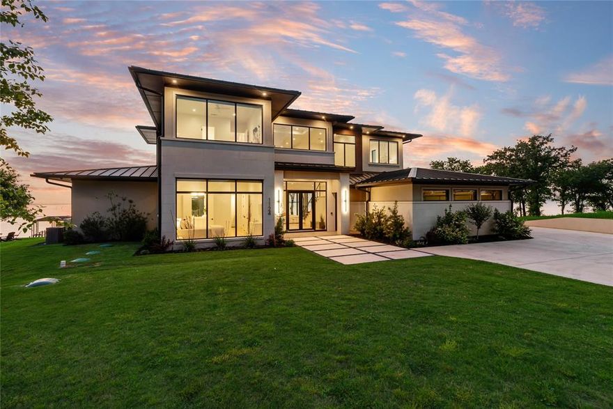 Welcome to the ultimate blend of contemporary luxury living and smart investing—this stunning lakefront estate isn’t just a dream home, it’s also a high-income producing *5-star* luxury short-term rental, with an impressive rental history. Even better? The sellers are ready to transfer the thriving rental business to the new owners, making this an incredible turnkey opportunity. From the moment you step through the front door, the craftsmanship and high-end finishes speak for themselves. The expansive main living room wows with soaring vaulted ceilings and a dramatic gas fireplace filled with sparkling glass rock—perfect for cozy nights in. The chef’s gourmet kitchen is a true showpiece, complete with a 6-burner gas range, custom cabinetry, and top-of-the-line appliances. With 5 bedrooms, each with ensuite access, 4 full baths, and 3 half baths, the home is designed for large groups. The primary suite is a sanctuary with floor to ceiling lake views and a luxurious ensuite bath with 2 custom designed closets (one doubles as a safe room). A spacious laundry room, 2 more utility areas, and a bonus exercise studio round out the amenities. Upstairs, guests will love the family room with its own balcony, dry bar, drink fridge, and ice maker—ideal for winding down the day. There's also game room with breathtaking lake views, making this home just as fun as it is relaxing.Step outside to paradise: a large covered patio with built-in grill, mosquito mister, and ceiling fans offers a seamless indoor-outdoor experience. Just beyond lies the infinity pool with a built-in fire pit feature and a jacuzzi spa—pure lakeside luxury. The boathouse comes equipped with a boat lift & jet ski lifts, ready for adventure at a moment’s notice. A 2-car garage stores your vehicles, while a separate garage is perfect for storing lake toys & lawn equipment. Whether you’re looking for a luxurious personal getaway, a high-end vacation rental, or the best of both worlds, this property has it all.