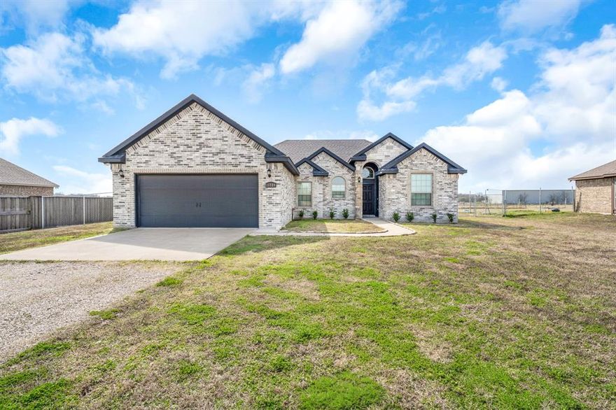 NEWER CONSTRUCTION ON 1 ACRE WITH NO HOA AND NO CITY TAXES. A RARE FIND AT THIS PRICE POINT AND SO CLOSE TO THE METROPLEX, THE LISTING WILL NOT LAST LONG! Built in 2020, this move-in ready 3 bedroom, 2 bath brick & stone home offers the perfect blend of modern design and country freedom. Situated on one acre just outside Terrell between I-20 and Hwy 80 in the Wills Point ISD, this home gives the space that buyers desire - room for pool, shop, RV parking, garden or outdoor living expansion. Inside, the open-concept layout features wood-look, tile plank flooring, abundant natural light, and spacious living and dining areas ideal for entertaining. The modern kitchen is designed for everyday living with granite counters, quality cabinetry with pulls, stainless steel & black appliances, center island, breakfast bar & adjacent pantry storage. Whether hosting friends or enjoying a quiet night in, this layout is flexible & functional. The oversized primary suite offers views of the property and a generous ensuite bath with dual sinks, tub-shower combo, granite counters & walk in closet with custom built ins. Secondary bedrooms with lighted ceiling fans and full guest bath are located in a separate wing of the home for privacy. With an attached two-car garage, extended driveway, fenced backyard, patio for cookouts, and flexible outdoor space, this property checks every box for buyers wanting acreage, privacy and newer construction near the amenities of the city. Bonus features include lighted ceiling fans in the living room and all bedrooms, new front landscaping, a whole house water filtration system with a new five year warranty & Starlink high speed internet system. This home shows like a model, has been professionally cleaned from top to bottom, and is move-in ready. Don't wait!