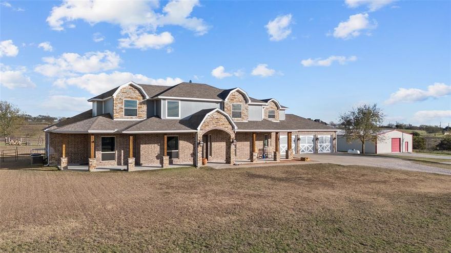 This Aledo residence offers the perfect blend of privacy, space, and timeless Texas appeal. Built in 2012 and set on a generous 13 acre homesite with a gorgeous winding tree lined road to the home. The expansive front porch is defined by a classic brick architecture and gives a peaceful sense of openness that defines Parker County living. Inside, the layout unfolds with comfortable elegance. Multiple living and dining areas create natural gathering spaces for everyday life, celebrations, and quiet evenings at home. Large windows invite soft natural light throughout the day, giving each room a warm, inviting feel. The private owner’s suite provides a quiet retreat, while additional bedrooms and baths offer flexibility for family, guests, and entertaining. There is a room for every family activity including, office, media room, game room and an exercise room. For the large families needing 5 bedrooms, this home is for you.
The heart of the home flows easily into the outdoors, where wide-open land becomes part of the experience. With ample space for a future pool and outdoor kitchen. 
Located within acclaimed Aledo ISD and minutes from I-20, the property provides quick access to Aledo, Weatherford, and Fort Worth—while still preserving the quiet country charm that makes Kelly Road so sought after. Just minutes from the upcoming Bluejack Ranch Golf Course—a world-class destination brought to life by Tiger Woods and designed to be a hub for golf, tennis, pickleball, and high-end social events—this property stands in the path of progress, perfectly poised for both personal enjoyment and future value. With rolling pastures, panoramic hilltop vistas
There is no HOA, offering added freedom and flexibility. The workshop is quality built and ready for any business. Measuring 40 x 75 totaling 3,000 square feet, 12 foot side walls, two 10 foot rollup doors, concrete slab, lights, and electric outlets. This property is the perfect setup for country living.