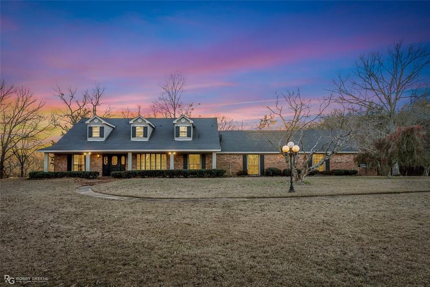 Stately Country Home on 6+ Acres – Your Dream Home Awaits! Discover the perfect blend of elegance, comfort, and country charm with this stunning 4-bedroom, 3-bathroom home, set on just over 6 acres of picturesque land. With spacious living areas, abundant storage, and beautiful natural surroundings, this home is designed for both relaxation and entertaining. Step into a lovely kitchen with a cozy breakfast room, seamlessly connected to a formal dining room—ideal for family meals and special occasions. The spacious den features built-in shelving and a wood-burning fireplace, creating a warm and inviting atmosphere, while your spacious living room allows for adult mingling and conversation. Need a peaceful retreat? The sunroom offers a serene space to unwind while watching deer, turkeys, and other wildlife right in your backyard. A major plus—your primary bedroom with an ensuite bath is conveniently located on the main floor! The custom-built primary closet includes built-in cabinetry, a makeup area, and a walk-in closet. Another main-floor bedroom provides flexibility, while two additional bedrooms are situated upstairs. Love to entertain? The oversized family room is perfect for a game room, media room, or holiday gatherings! Just off this space, you'll find a large storage room with built-in shelving, plus room for a freezer and extra refrigerator. Outside, the property boasts multiple storage buildings, an RV carport, and plenty of space to explore. And the best part? Lake Claiborne is just minutes away, offering boating, swimming, and fishing at your convenience. This incredible home has it all—space, storage, and stunning surroundings! With just a little TLC & some updating, this home could be a true show stopper. Don't miss out—schedule your private tour today!