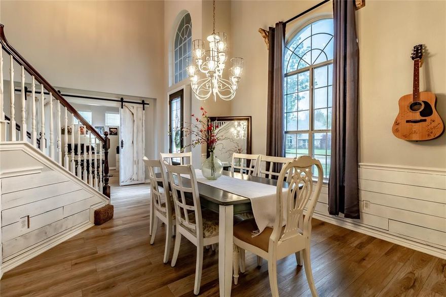 A house that combines elegance, functionality, and comfort in perfect harmony. This dream home promises a lifestyle of luxury and ease for its occupants. As you approach the house, the first thing that captures your attention is the dramatic entry facade. This welcoming portal sets the tone for the rest of the home, hinting at the elegance that lies within. Stepping through the entrance, you will arrive at the formal dining space to your left and an office space with barn doors to your right. The formal dining area is marked by its sophisticated shiplap decorative wall, adding texture and warmth. As you step further into the home, you find yourself in a breathtaking two-story living area. The space is flooded with natural light, thanks to the striking palladium windows. The high ceilings enhance the feeling of spaciousness, making this an ideal spot for relaxation or social gatherings. The heart of the home, the kitchen, is nothing short of a culinary dream. It features a spacious island that serves as a hub for both cooking and casual dining, complete with a breakfast nook for morning meals and an additional covered outdoor space great for morning coffee. A butler's pantry or coffee bar add convenience, ensuring everything you need is within reach. The luxurious primary suite, located on the first floor, offers a serene retreat. It boasts a spacious bedroom area, complemented by a lavish en-suite bathroom that includes separate sinks, a shower, and a soaking tub. Outside, Three additional bedrooms, 2 full baths and secondary living space are located upstairs. The backyard oasis is a true highlight of the home. It features a stunning pool surrounded by lush landscaping, creating a resort-like environment. A covered area provides shade and comfort, making it ideal for outdoor dining or lounging. This space is perfect for enjoying sunny days with family and friends, adding another layer of luxury to this dream home.