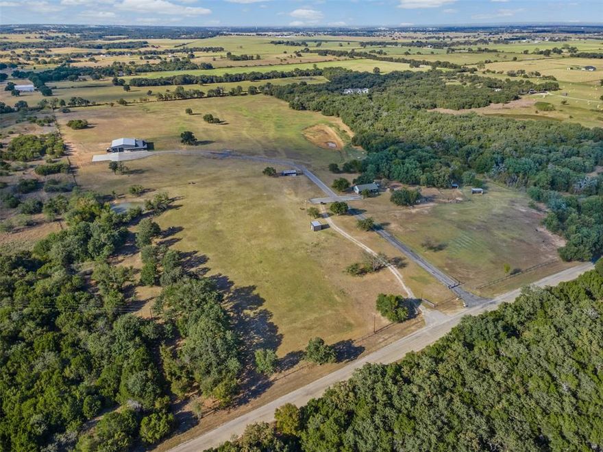 Experience the ultimate Texas lifestyle at 9700 Nix Road. A rare ag exempt, 40+ acre estate in Tolar offering two homes, privacy, luxury, and breathtaking Country views. Every detail of this property reflects sophistication, versatility, and Texas sized living. At the center of the acreage sits a custom-built 4,600+ sq. ft. residence that perfectly balances elegance and everyday comfort. Inside, you'll find 4 spacious bedrooms, each with its own private bath. The open-concept design highlights a gourmet kitchen with premium appliances, separate ice maker, expansive island, butlers pantry and seamless flow to the living area with 2 fireplaces to complete the ambiance. A dedicated pet room complete with a water bowl filler. The primary suite has a private laundry room, hidden safe room and access to the outdoor oasis. The spa like primary bath was designed with the couple in mind. Featuring dual vanities, dual toilet rooms, separate walk in closets, massive shower with multiple shower heads and large soaking tub. Step outside to your own resort-style oasis with a stunning pool, spa, double grotto, slide, outdoor kitchen, full outdoor bath and expansive covered patio ideal for entertaining. Whether you’re hosting friends or enjoying quiet sunsets, this property captures the beauty and peace of rural Texas living. The attached 2300sqft heated and cooled drive through shop can easily fit 8 cars with space for equipment and toys. The 1118sqft separate guesthouse (not included in sqft) has 2 bedrooms and 2 full bath perfect for multi-generational living, guest quarters or potential rental. With fenced pastures, cross fenced animal pens, mature trees, and ample space for livestock or additional structures, this estate offers unmatched flexibility for ranching and recreation. Located in the highly sought-after Tolar ISD with easy access to Granbury, Stephenville, and the DFW Metroplex.