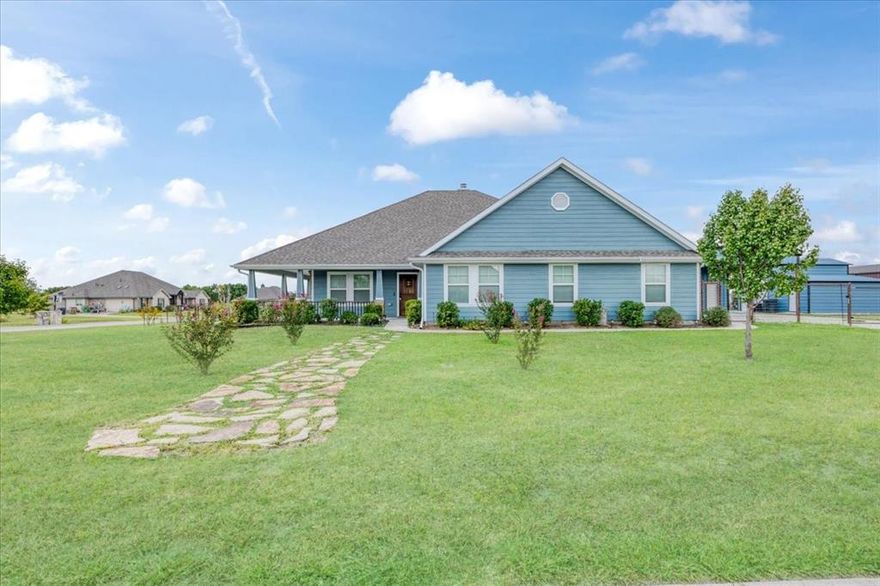 Welcome to Caddo Fork Estates with NO HOA and NO CITY TAXES!!  Discover the perfect blend of country charm and modern comfort in this exquisite 3-bedroom, 2-bath home with FRESH EXTERIOR PAINT, tucked away on a corner lot just outside the city limits of Caddo Mills, TX. A spacious 530 sq. ft. front porch sets the tone, inviting you to relax and take in the peaceful surroundings and lovely views of your pipe fenced back yard—The additional side and rear covered porches provides even more outdoor living space. Inside, the open floor plan boasts lovely solid wood floors, a 15x20 great room centered around a warm and cozy wood-burning fireplace The chef-inspired kitchen offers a stunning 8x5 granite island with electric, farmhouse sink, granite countertops, abundant cabinetry, a large pantry, and an electric range—open to the breakfast and living areas for seamless entertaining. The master bedroom is spacious and offers carpeted floors, ceiling fan, & a HUGE CUSTOM walk in closet and flows effortlessly into the spa-like master bath with skylight, Garden tub, separate tile shower and his and her vanities. The secondary bedrooms are roomy with ample closet space, lovely carpet and ceiling fans.  In addition, the property offers an electric gate for privacy and is nestled on 1.509 acres, with the backyard enclosed by pipe fencing and two gates.  For the hobbyist, craftsman, or extra storage needs, you’ll find NOT ONE, but TWO INSULATED WORKSHOPS: a 24x24 workshop with electric & a 10' RU door, 2 exterior doors & an extended 20X24 front covered carport with concrete parking; and ANOTHER 23x20 workshop with electric, a 10' roll-up door with a 20x11 rear overhang for outside parking or storage. This home checks every box for luxury, comfort, function, while country living makes it perfect for the kids and pets with plenty of room to romp!  Just minutes from town, yet offering the tranquility you deserve.  A MUST SEE!