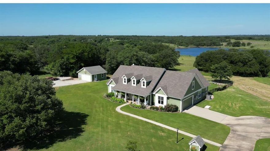 Primarily one-story home on just over 3 acres provides ideal space for hobbies, equipment, gardening, or simply enjoying the privacy and views around the lake. Adjacent 3 acre tract also available (MLS #20877045). Purchase both properties together for approximately 6 acres total. This energy efficient home has 60 OWNED solar panels and battery backup designed to offset most, if not all, of the electric bill. All main living areas and bedrooms are downstairs with only a private guest suite and full bath upstairs. This 4 bedroom plus office, 3.5 bath home offers 2,550 sq ft with high ceilings, oak flooring in the living and dining areas, tile in the kitchen, baths and halls, with vinyl picture windows throughout. Living room features a gas fireplace with granite surround. Kitchen includes custom maple cabinetry and granite countertops and opens to both the living and breakfast area. Dedicated office with built-in desks. Private primary suite with safe room & storm shelter closet. Two bedrooms share a Jack & Jill bath with granite countertops, while the upstairs bedroom and full bath offer a private space ideal for guests or multigenerational living.  Walk-in floored attic offers excellent storage. Structural Insulated Panel construction for added efficiency. Central vacuum. New AC in 2023 and upstairs mini split in 2022. Roof replaced in 2025. Backyard designed for entertaining with resort-style pool featuring infinity edge, fountains, slide, lighting and new filter (2025), upper and lower concrete pool decking, covered back porch, fenced yard, raised garden beds with drip irrigation and deer fencing, and sprinkler system with Tifway 419 Bermuda grass. Additional features include fiberglass tornado shelter that will seat 6, greenhouse with a 1 car garage, an additional detached 2 car garage & workshop, RV pad with electric hookup, concrete driveway, and water well for irrigation. Property includes ownership in the community lake lot that is stocked with fish.