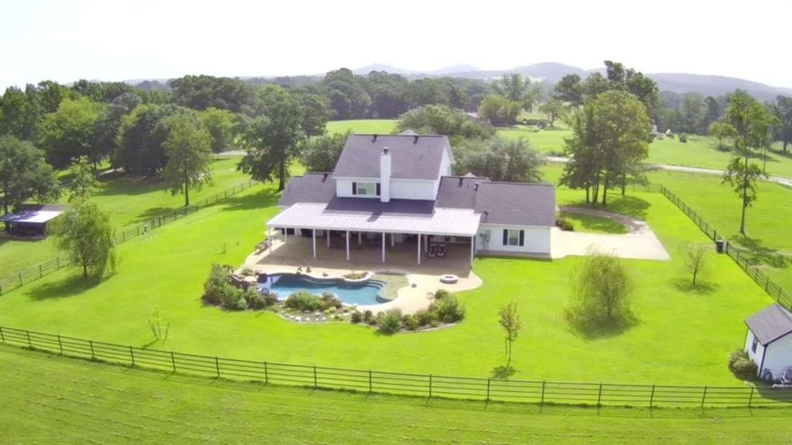 Welcome to this one-of-a-kind modern farmhouse with timeless charm designed for refined entertaining and everyday relaxation. The home features four large bedrooms, two and a half baths, a formal dining room, a dedicated office, and a three car garage. The open concept layout includes the kitchen, dining, and a living room that has double french doors that let in all the natural light, with each room featuring extensive crown molding and beautiful plantation shutters. The living room offers stunning views of the sparkling gunite pool, waterfall, and 1800 sq. ft. covered patio for entertaining. Two large bedrooms downstairs, with a Jack and Jill bath and a recently updated shower. Two large bedrooms upstairs, including the vaulted master suite which has dual vanities, a soaking tub, a separate shower, and a large closet boasting can lighting and a chandelier. There is a hidden safe room for storing and organizing all of your hunting gear. Visualize ten foot ceilings, extensive crown molding, custom hardwood floors, and ceiling fans throughout. Outdoors you will find a security gate with a keypad entry, an insulated 30x40 shop with two 10x12 roll up doors, skylights and a 15x30 overhang, a freshly painted 2 stall equine stable with tack room, a large pond stocked with bass and bream, and an oversized dock. The ag-exempt acreage and yard are pipe fenced and cross-fenced, and contains heavy duty hog wire as well. The deep well supplies water to the pool, sprinkler system, and animal watering. This gorgeous property offers serenity with large oaks and pines, and stunning views of the Barnwell Mountain range, and it’s only a 35 minute drive to Longview. This home has it all, truly a place where you can create lasting memories.