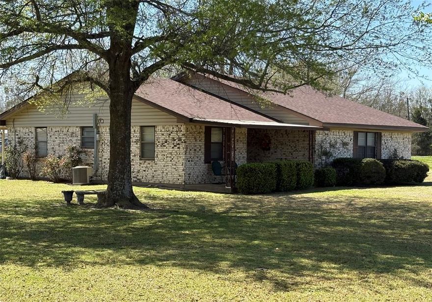 Opportunity knocking with this well maintained 3 bedroom brick home with multi-use shop located in high visability area. Providing a corner lot with access on 3 sides allows for a great place to live and operate a business. This cozy 3 bedroom has no wasted space and the open concept from living area to kitchen makes it very appealing and spacious. The kitchen also has a bar area for added eating space, custom cabinets and alot of counter space. Bedrooms have ceiling fans and the master has a half bath. The attached garage opens to a large covered patio for relaxing and entertaining.
The shop (26x45) has two roll up doors, bathroom and plenty of storage space. The shops location (Hwy 11 & FM 2653 intersection) provides opportunity with high traffic volume and visibility as a great location for retail, repair, mechanic shop, fruit stand, etc. The road frontage on 3 sides allow for plenty of space for truck access and parking. Also on the property is a covered (14x38) RV parking with slab and electricity. There is also a small storage building located near the house for additional storage. Located between Sulphur Springs and Commerce and only about 4.5 miles from I30 makes this a great location for multi use.