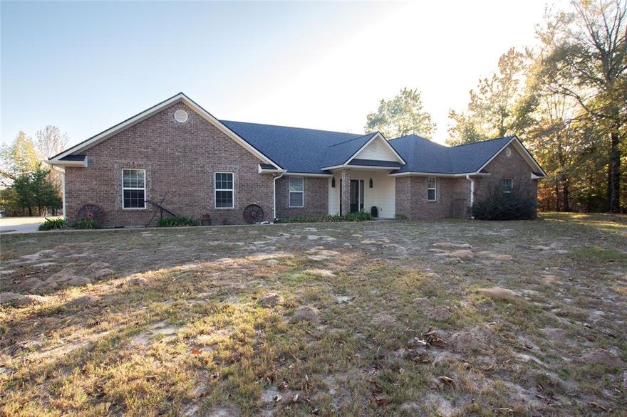 Welcome to your private retreat in the Hawkins, Holly Lake Ranch area! About 45-60 minutes from Tyler or Longview, and nestled on over 4 mostly wooded acres, this 3-bedroom, 2-bathroom home offers the perfect blend of comfort, space, and value. The open floor plan is complemented by a split bedroom layout for added privacy and features composite countertops and stylish finishes throughout the kitchen and other living areas. The spacious primary bedroom opens to the patio and has a well-appointed en suite featuring dual vanities, a soaking tub, a separate shower, and a his-and-hers walk-in closet. Enjoy peace-of-mind with a whole-home security system and a Generac generator, ensuring you'll never be without power. The 20x30 workshop includes a nearly-new 80 gallon air compressor and is ready for any project you're willing to throw at it. Fiber internet is ready to stream your favorite content, and the roof was replaced in October 2025. Whether you're relaxing on the patio, exploring your acreage (there are freshwater springs near the back of the property), or just watching the stars overhead, country privacy and modern comfort are what make this house your home. Don't miss the opportunity to own your own acreage in this well-loved East Texas community.