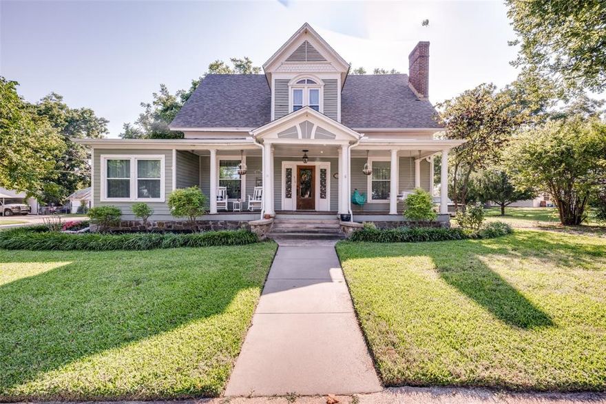 Set among mature oak and pecan trees in a sought-after location, this meticulously updated 1907 residence seamlessly combines timeless elegance with modern comfort. The home features original hardwood floors, a refined library-sitting room, separate living area, formal dining room and a sun-filled sunroom—each space offering distinctive warmth and character. With four spacious bedrooms, including a primary ensuite conveniently located downstairs and three additional large bedrooms plus a full bath upstairs, the layout provides both flexibility and privacy. A powder bath is ideally situated on the main level for guests.  The kitchen overlooks the landscaped backyard and offers period-appropriate cabinetry, quality stainless steel appliances, a walkthrough utility area with access to the backyard, and an iconic walk-in pantry. Enjoy the gracious front porch, ideal for relaxing as community parades pass by. The expansive backyard invites various activities: enjoy your morning coffee or evening tea on the shaded deck, stroll through lush St. Augustine grass, garden, raise chickens, swim in the above-ground pool, or utilize the workshop in the detached three-car garage with an apartment above. This property provides quiet, private living with income potential from the separate living area, making it an exceptional opportunity for those seeking a blend of historic charm and contemporary convenience.