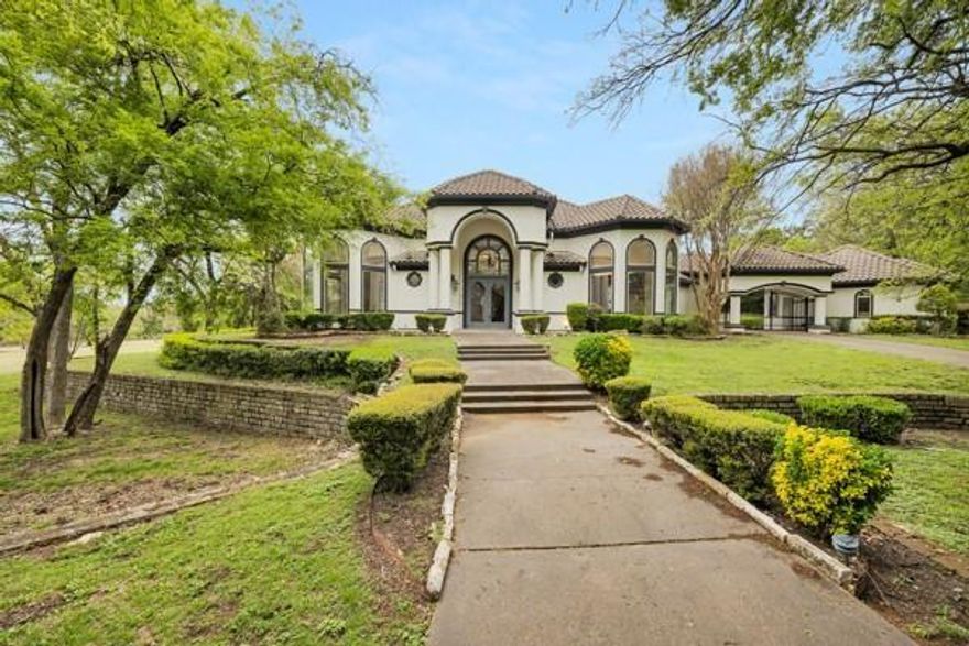 Step into a world of elegance and comfort in this 10,980 sq. ft. estate, nestled in the prestigious gated Thorntree golf-course community. Designed for those who love to entertain and unwind, this 5-bedroom, 6.5-bathroom mansion offers a seamless blend of sophistication and resort-style living.
From the moment you walk through the grand entryway, vaulted tray ceilings, intricate crown molding, and rich wood and tile flooring set the stage for a home that exudes both charm and grandeur. The gourmet kitchen—outfitted with Viking appliances, granite countertops, an oversized island, and an expansive pantry—is a chef’s dream and the heart of the home. For book lovers, a beautiful private library offers the perfect retreat, while the dedicated home office ensures a productive workspace with privacy and elegance. And when it’s time to relax, head to the spa room, thoughtfully designed to accommodate massage beds and ultimate relaxation—your personal wellness sanctuary at home. The primary suite is nothing short of a retreat, featuring a custom walk-in closet with built-in shelving and a storage island. Cozy up by the double-sided fireplace, which seamlessly connects the suite to the spa-like master bath, complete with dual vanities, a jacuzzi tub, and a separate shower. Upstairs, a grand iron staircase leads to a spacious media room, game room, and additional bedrooms, ensuring that there’s room for relaxation and recreation. And the outdoor space? A true oasis—a sparkling pool, an indoor spa, and a private pond create the perfect setting for unforgettable gatherings. With a five-car garage, this home effortlessly combines functionality with luxury. Just 12 minutes from Dallas Executive Airport, 20 minutes from downtown Dallas, and a short drive to top shopping destinations, and 14 minutes from Joe Pool Marina. This estate offers the best of privacy, luxury, and convenience. Your dream lifestyle starts here—schedule a tour today!