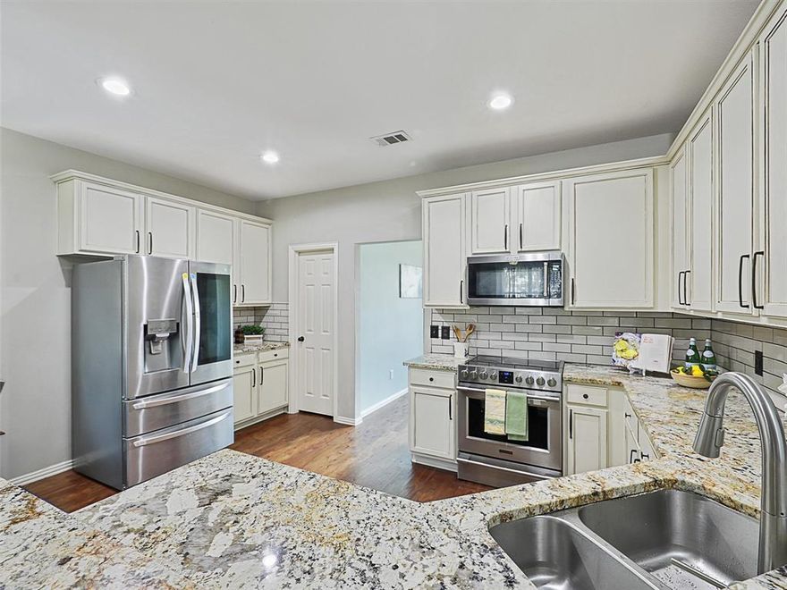 Move right in to this charming, four-bedroom gem nestled on a peaceful cul-de-sac in a welcoming neighborhood. The home instantly impresses with a soaring two-story entry and hardwood floors extending throughout the main level. The main floor is designed for both entertaining and everyday living. You'll love the spacious, French Country eat-in kitchen, a true heart of the home, featuring granite countertops, subway tile backsplash, under-cabinet lighting, a large pantry, and newer stainless steel appliances. The cozy, custom breakfast nook with built-in bench seating flows seamlessly into the family room, complete with a gas fireplace. A separate formal dining room offers flexibility for large gatherings or can serve as a second downstairs living space. For the modern professional, a private downstairs office boasts high ceilings and a stylish sliding barn door for quiet focus. Upstairs, the home continues to impress with newer carpeting throughout. A large second living area or game room provides a perfect hang-out spot. The spacious Primary Suite is a true retreat, featuring a dramatic sliding barn door entry, dual vanities, a separate shower and tub, and an extended walk-in closet. All secondary bedrooms are well-sized, each featuring a walk-in closet and ceiling fan for comfort. Outside, enjoy the shaded backyard and look forward to harvesting the amazing, sweet peaches from your very own large peach tree. Don't miss this opportunity for a blend of comfort, charm, and convenience!