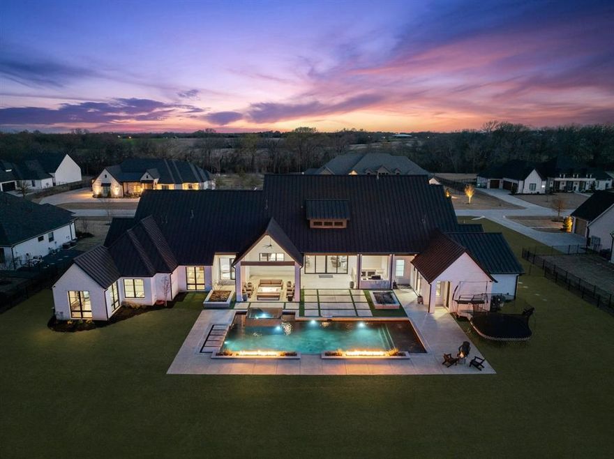 Introducing the Residence at Honey Lane, a custom-built home in an exclusive gated community, designed for those who seek unmatched craftsmanship and style. Set on 1.2 acres, this property features an open-concept layout that merges upscale design with everyday ease. Premium wood flooring runs throughout, enhancing high-end finishes. The living room, with wood beams and a gas fireplace, is flooded with natural light from vast windows. An indoor-outdoor atrium with its own fireplace and glass wine cellar adds elegance. At the heart of the home, the gourmet kitchen is equipped with top-tier appliances, a spacious island, and designer light fixtures. The expansive primary suite offers a sitting area, private backyard access, and an integrated gym. The luxurious en-suite bathroom features a double vanity, frameless glass shower, soaking tub, and built-in coffee bar. The walk-in closet includes an island for ample storage. The dedicated media and game rooms provide endless entertainment options. For convenience, there’s a mudroom and a spacious laundry room with built-in storage. Outside, over 1,000 square feet of covered outdoor living space includes a heat pool, spa, fire feature, and a dramatic A-frame patio with an outdoor kitchen and fire pit. The 3-car garage offers ample room for vehicles, plus an additional garage with 10 foot ceilings that is ideal for a boat or car lift. With a standing-seam metal roof and timeless architecture, this home combines modern appeal with lasting sophistication.