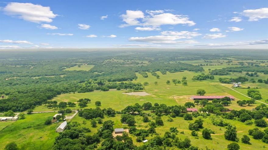 This is a rare find & unique opportunity to own 85 gorgeous acres of coastal fields just 1 hour west of the DFW Metroplex. And, it has a covered arena! Fenced & cross fenced, this property can support cattle or equine operations. Looking for a getaway where you can watch deer and wild turkey as you fish in 1 of the property's 2 ponds, this is the place. Need a place to expand your working ranch, there's space to customize and make this one extra special. The home has good bones w some updates and just needs cosmetic finishes. The stall barn could easily be improved with runs as there are pipe pens off both sides. The shining gem is the 100x265 metal building. Inside, you'll find a 100x50 enclosed shop with electricity, a large sliding door and plenty of space for storage or tinkering. There's also a 30x100 overhang for additional storage. Off the back, there is a 165x80 covered riding arena that could suit many disciplines. Imagine the breakaway calf lane you could have!