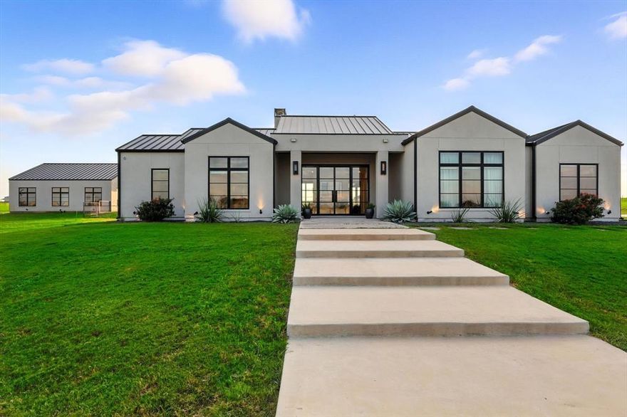 Welcome to 11102 East Rocky Creek Road in Crowley, Texas, a modern custom estate offering the perfect balance of luxury, functionality, and wide-open Texas living. Privately situated on over 11 acres within the gated and deed-restricted Rocky Creek Subdivision, this exceptional property includes a stunning main residence, a newly built guest house, a resort-style backyard. Built in 2019, the main home offers nearly 3,800 square feet of thoughtfully designed living space with four spacious bedrooms, each featuring its own ensuite bathroom. High ceilings, real wood flooring, custom cabinetry, and multiple living areas elevate the home's interior, while the open-concept floor plan and gourmet kitchen with gas cooktop, butler’s pantry, and oversized island make it ideal for entertaining or family gatherings. Completed in 2023, the detached guest house adds over 1,100 square feet of additional living space, including two bedrooms, a full kitchen with butcher block countertops, open living and dining areas, and a stylish garage with two motorized doors one of them glass to maximize backyard and pool views. This versatile space is perfect for guest accommodations, a private home office, gym, or entertainment suite. Enjoy seamless indoor-outdoor living with a sparkling in-ground pool, full outdoor kitchen, and a cozy fireplace perfect for year-round relaxation and entertaining. Both the main house and guest home include large attached garages. The property benefits from agricultural exemptions and includes two separate tax parcels, offering potential tax advantages and flexibility. Residents of Rocky Creek enjoy exclusive access to miles of private hiking and biking trails, as well as fishing opportunities along the creek, making this community ideal for those seeking a blend of natural beauty and upscale living. Located just minutes from Fort Worth, this modern Texas estate is 10 minutes from the SW medical district and multiple private school options.