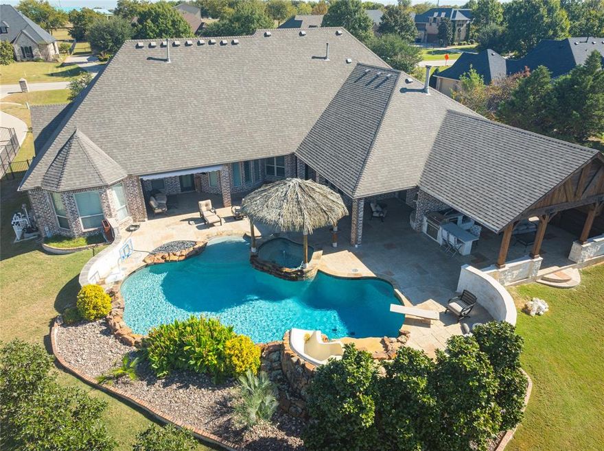Assumable VA loan at 2.25%!!! Experience resort style living in this exceptional custom home by Dave R Williams, perfectly positioned on a sprawling one acre lot in one of Prospers most desirable areas. Designed with craftsmanship and comfort in mind, this residence blends elegance with unforgettable outdoor amenities. This home welcomes you with vaulted ceilings accented by rich wood beams, custom millwork, and thoughtfully curated finishes throughout. A huge walk in pantry and plantation shutters add both convenience and sophistication. The dedicated office features custom built-ins. Step outside to the perfect summer set up complete with a tiki covered spa, sparkling pool with SLIDE and outdoor covered entertainment area. 4 CAR GARAGE and extended driveway allows for a lot of parking. Room for pets and play equipment. No through traffic on the street. Close to all major shopping and access to DNT but totally feels like country living! Experience the best of both worlds.  This is your chance to have it all. Some furniture can convey.